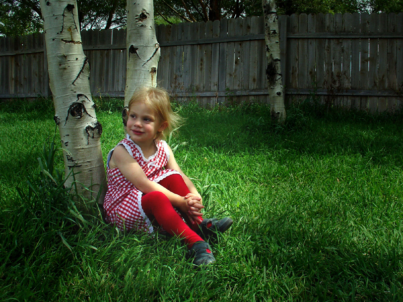  Ein Mädchen sitzt vorm Baum 